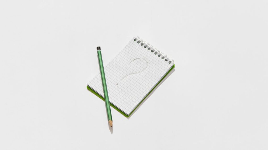 はてなマークを書いたメモ帳のイメージ