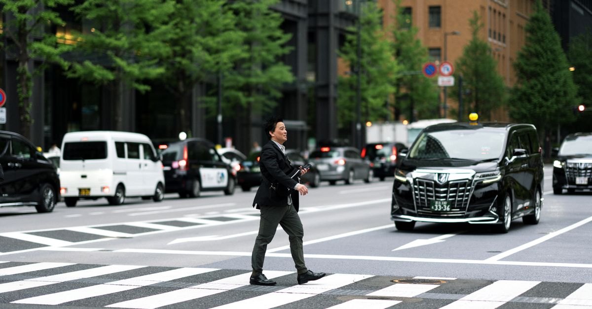 東京の交差点を歩く現役世代のビジネスマン